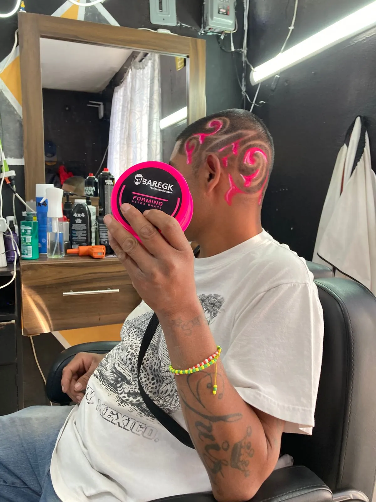 Interior de The OneBarber Shop — silla y mural